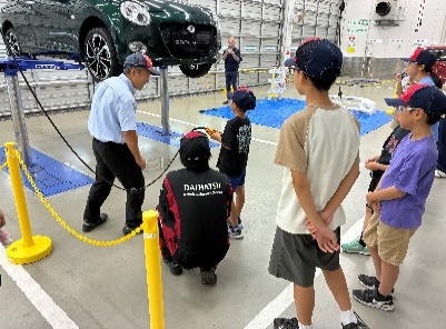 整備工場でスタッフから説明を受ける参加者のみなさん
