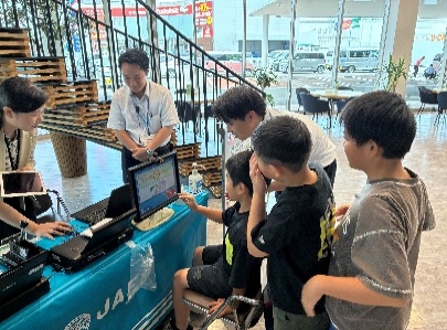 スタッフと一緒にモニターを見る参加者
